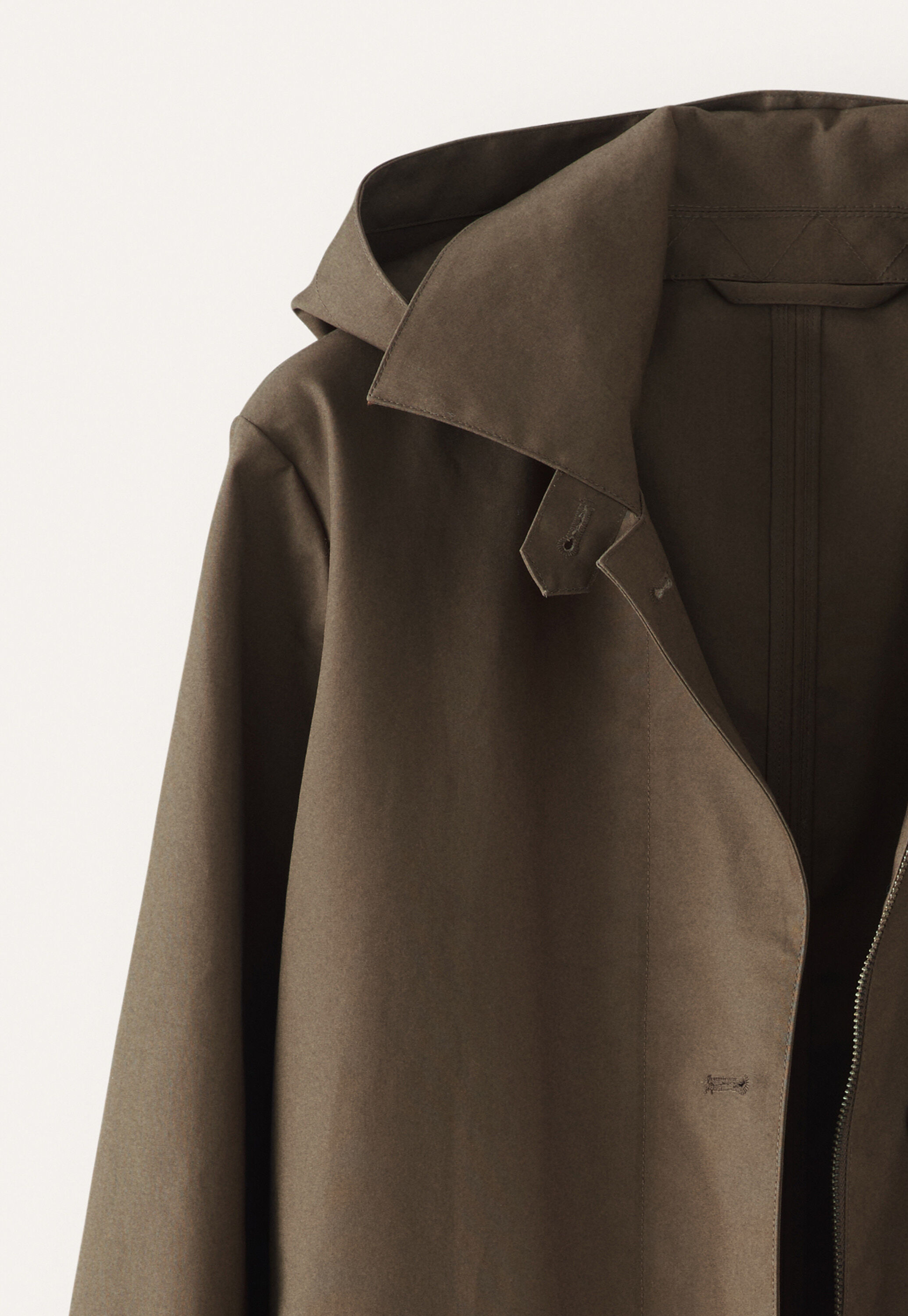 A contemporary trench coat in bonded, water-repellent cotton with a removable hood for when the sun comes out.